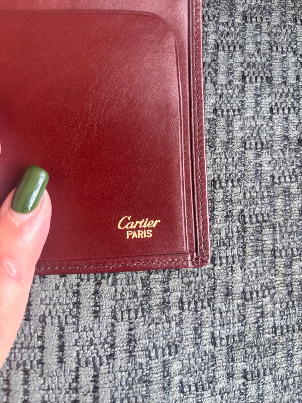 Cartier burgundy leather card case with gold hardware.